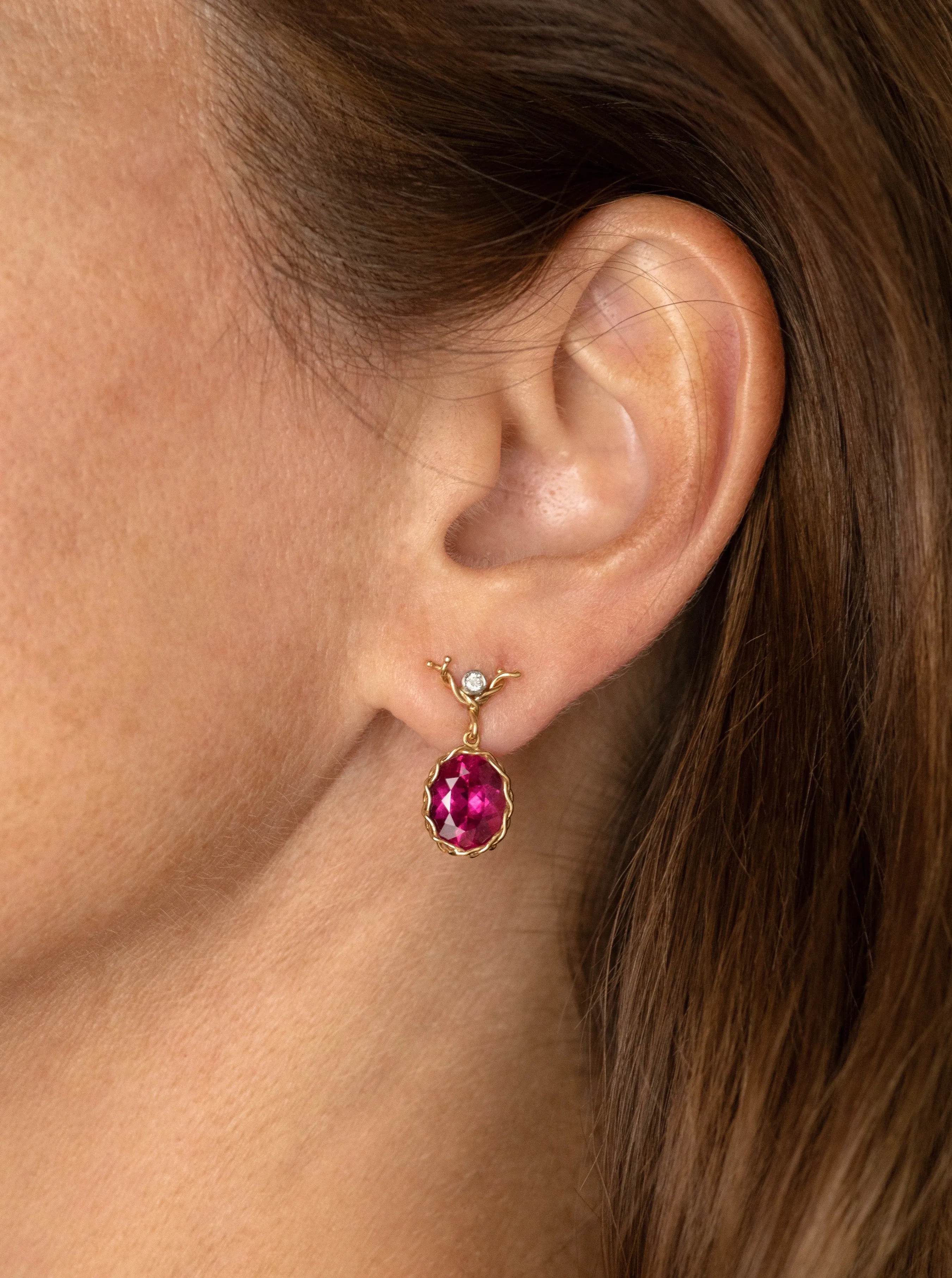 Rubelite faceted oval drop earring in 18k yellow gold vine with diamond ear wire.
